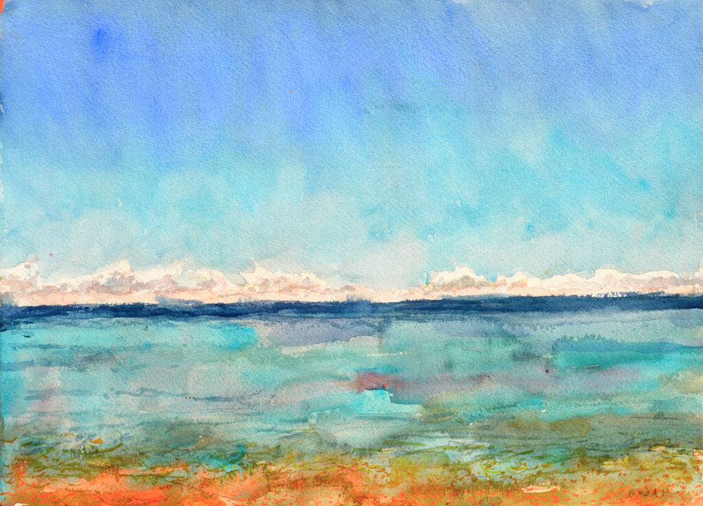 Blazing cobalt and turquoise sky ending with a row of sparkling white clouds over an ocean ranging from indigo to turquoise to violet to orange gold